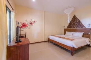 a bedroom with a bed and a dresser at Twin Bay Resort - SHA Extra Plus in Ko Lanta
