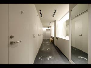 korytarz z białymi ścianami i rysunkami na podłodze w obiekcie 9h nine hours woman Kanda w Tokio