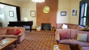 uma sala de estar com dois sofás e um piano em Foveaux Hotel em Bluff