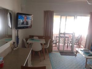 a living room with a tv on the wall and a table at Apartment in Dolphin Heads in Eimeo