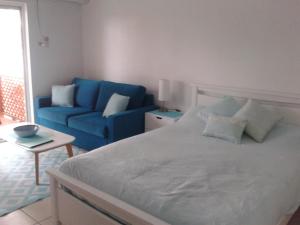 1 dormitorio con 1 cama y 1 sofá azul en Apartment in Dolphin Heads, en Eimeo
