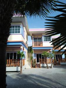 un edificio con palmeras delante en Sansook Chaolao, en Chao Lao Beach
