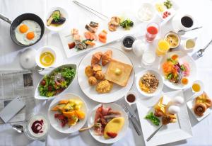 una mesa blanca con platos de comida. en Kanazawa Tokyu Hotel en Kanazawa