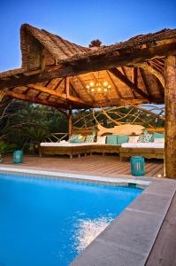 une pergola en bois à côté d'une piscine dans l'établissement Villa Reve de Sud, aux Issambres