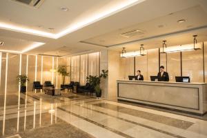 two people at a reception desk in a hotel lobby at Summit Hotel Seoul Dongdaemun in Seoul