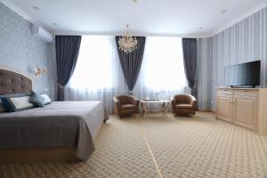 a bedroom with a bed and a flat screen tv at Hotel Bahetle in Ekibastuz