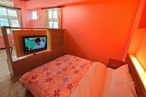 台東市的住宿－蕃茄咖啡民宿，一间带床和电视的小卧室