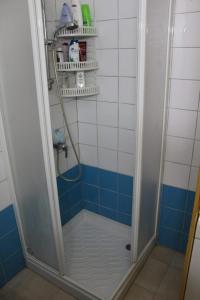 a bathroom with a shower with blue and white tiles at Kaparris Apartment in Paralimni
