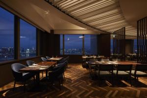a restaurant with tables and chairs and a view of the city at Grand Nikko Tokyo Daiba in Tokyo