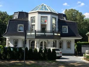 uma casa branca com um telhado de gambrel em Villa Fallingstar em Bad Saarow