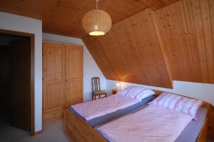 a bedroom with a bed and a wooden ceiling at Ferienwohnungen Wulfshof in Schneverdingen