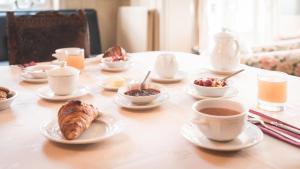 un tavolo con piatti e tazze di caffè di Manoir de Sens a Beuvron-en-Auge