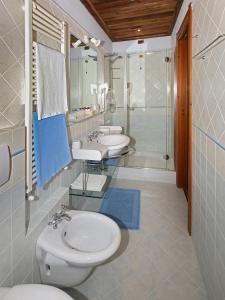 łazienka z 2 umywalkami, toaletą i prysznicem w obiekcie Chalet Chez Nous w mieście Sauze dʼOulx
