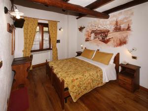 a bedroom with a bed and a painting on the wall at Chalet Chez Nous in Sauze dʼOulx