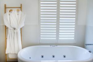 a white tub in a bathroom with a window at Haven on the Park in Perth