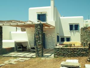 vistas a una casa con una pared de piedra en Almyra Yellow Villa en Kithnos