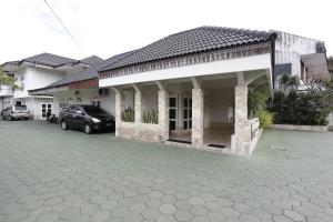 una casa con un coche aparcado delante de ella en RedDoorz Plus near Adisucipto Airport 2 en Yogyakarta