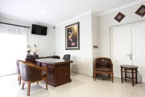 an office with a desk and chairs in a room at RedDoorz Plus near Adisucipto Airport 2 in Yogyakarta
