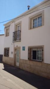 Un bâtiment blanc avec des fenêtres à barreaux noirs. dans l'établissement Sueños de Monfrague, à Torrejón el Rubio