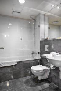 
a bathroom with a toilet, sink, and bathtub at Majestic Plaza Hotel Prague in Prague

