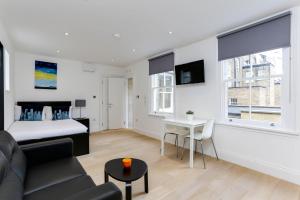 a living room with a bed and a table at Kings Cross Serviced Apartments by Concept Apartments in London +35 photos