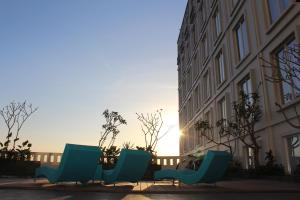 a row of blue chairs on a sidewalk next to a building at Grand Keisha Yogyakarta in Yogyakarta