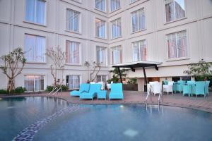 een binnenplaats van het hotel met blauwe en witte tafels en stoelen bij Grand Keisha Yogyakarta in Yogyakarta