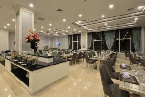 a restaurant with tables and chairs in a room at Grand Keisha Yogyakarta in Yogyakarta