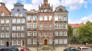 een groot gebouw met auto's geparkeerd voor het bij Dom & House - Apartments Old Town Ogarna in Gdańsk