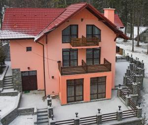 a large house with snow on the ground at Pensiunea Turistica Delmonte Holiday in Sinaia