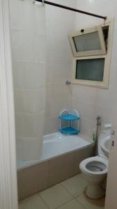 a bathroom with a tub and a toilet and a sink at Al-Madina Tower Apartment in Marsa Matruh