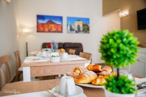 a table with a plate of croissants and bread on it at Quinto Stabile Rooms&Suite in Palermo