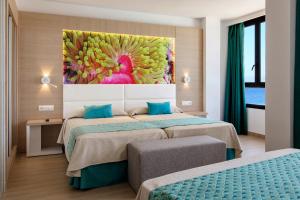 ein Schlafzimmer mit 2 Betten und einem Wandgemälde in der Unterkunft Marvell Club Hotel & Apartments in Bucht von San Antonio