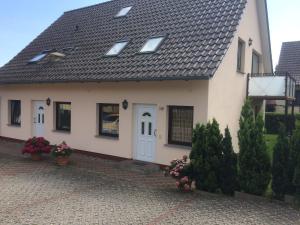 a white house with a black roof at Gästehaus am Fischerweg in Lauterbach