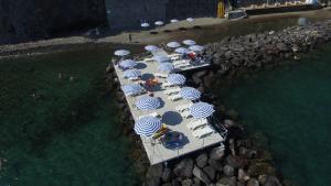 a group of tables with blue and white umbrellas at Le Querce Resort Sea Thermae & Spa in Ischia