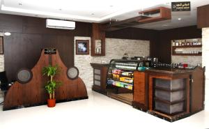 cafetería con barra y bar con planta en Rest Night Hotel Suites - Al Nafal, en Riad