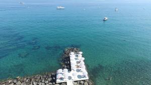 a group of people standing on a pier in the water at Le Querce Resort Sea Thermae & Spa in Ischia