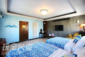 Un dormitorio con una cama y un televisor de pantalla plana. en Tomato Coffee B&B, en Taitung