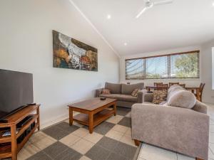 ein Wohnzimmer mit 2 Sofas und einem Flachbild-TV in der Unterkunft Drifters Apartment in Noosaville