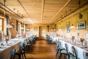 una fila di tavoli in una stanza con pareti in legno di Dolomites Living Hotel Tirler ad Alpe di Siusi