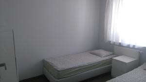 niewielka sypialnia z 2 łóżkami i oknem w obiekcie Apartament Nadmorski Jelitkowo w Gdańsku