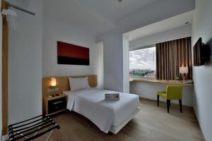 Ένα ή περισσότερα κρεβάτια σε δωμάτιο στο Whiz Prime Hotel Sudirman Pekanbaru