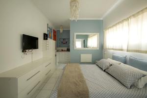 a blue and white room with a bed and a tv at J Bay Dreaming in Jeffreys Bay