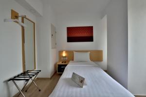 Ένα ή περισσότερα κρεβάτια σε δωμάτιο στο Whiz Prime Hotel Sudirman Pekanbaru