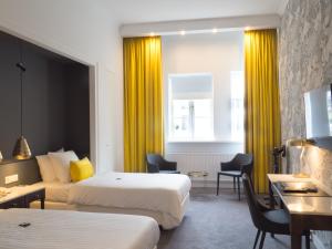 a hotel room with two beds and yellow curtains at Van der Valk Hotel Hildesheim in Hildesheim