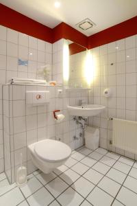 a bathroom with a toilet and a sink at Apart Hotel Sehnde in Sehnde