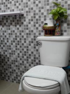 Baan Chanoknunt Resort Pai في باي: مرحاض أبيض في حمام به جدار من البلاط