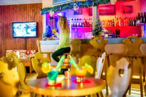 una mujer sentada en un bar en un restaurante en Chalet ATC Routes du Monde Argentiere-Chamonix, en Chamonix-Mont-Blanc