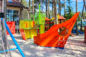 a playground with colorful playground equipment in the sand at Ośrodek Wypoczynkowy Relaks i Apartamenty in Łeba