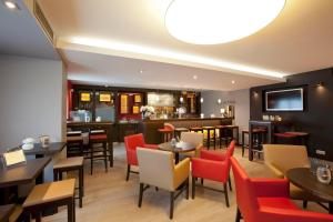 a restaurant with tables and chairs and a bar at Apart Hotel Sehnde in Sehnde